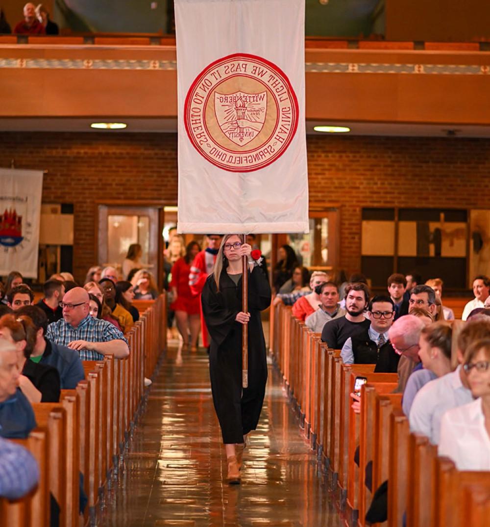 赌博平台 Student with Banner at Honors Convocation